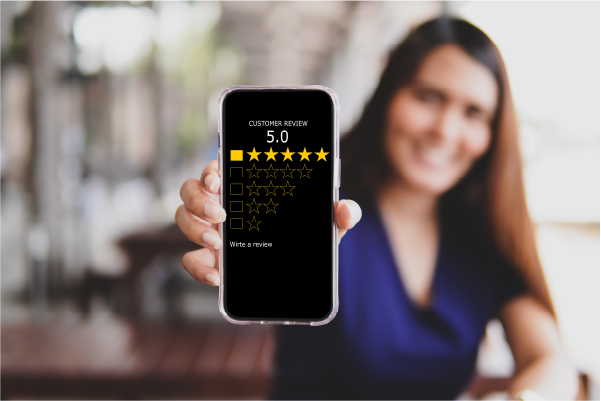 Photo of woman holding a phone with a 5 star review