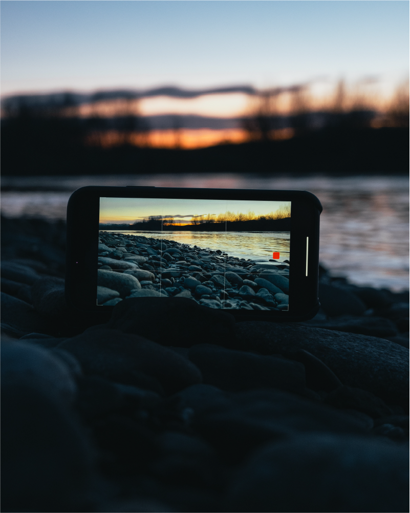 photo of smart phone taking video of a sunset